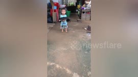 Terrible twos! Toddler somehow gets stuck in plastic tray