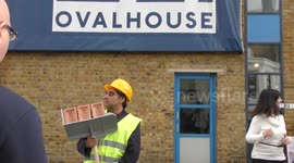 SANJEEV BHASKAR poses as builder with a hod of bricks