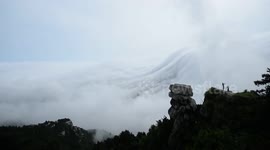 Absolutely stunning waterfall-like cloud formations in mountain range