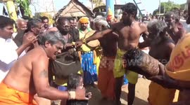 Devotees line up to have coconuts smashed open on their heads during Indian ritual