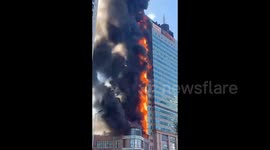 Crowd flees as office building engulfs in flames in China