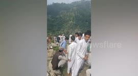 Locals gather on hillside where cable car is stuck in Pakistan