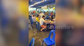 Unfazed diners carry on with dinner as flood fills restaurant in Thailand