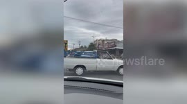 Pet pooch stands on pick-up truck while vehicle moves
