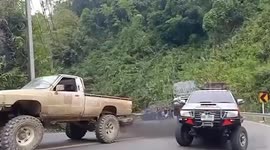 Tow trucks battle to drag conked-out truck up steep hill