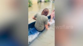 Family's kayak capsizes as they float through flood outside their home