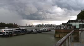Heavy rain from the thundstorm hits Greenwich causing people to hide from the torrential downpour