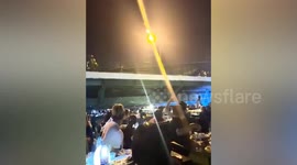 Floating restaurant passes under bridge along river in Thailand