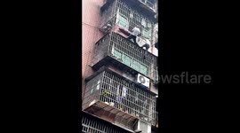 Brave neighbours save girl dangling from sixth-floor window in southern China
