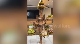 Awesome festival costume has four tiers of trays loaded with food