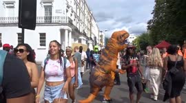Crowds having fun as T-Rexes drop off their heads for small talk at Notting Hill Carnival 2023