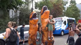 Children enjoy photo sesion with T-Rexes at Notting Hill Carnival 2023