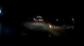 Electricity transformer explodes as motorist drives during storm