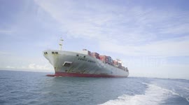 Multi lens filming of cargo ships sailing at sea and approaching shore.