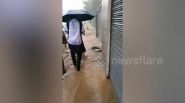 Schoolchildren try to cross raging Super Typhoon Saola floods in the Philippines