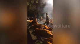 Monks boil herbs and sleep under steam in mats outside Buddhist temple