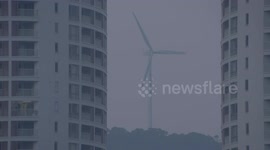 Fixed filming of wind power behind residential buildings.