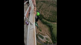 Basejumper hangs from bridge