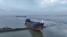 Huge cargo ship stranded on trestle in shallow waters in China