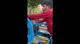 street juice vendor makes sugarcane juice using a manual machine