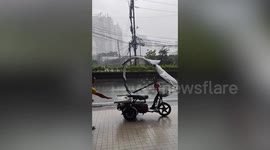 Typhoon Haikui winds blow electric bike away from its rider