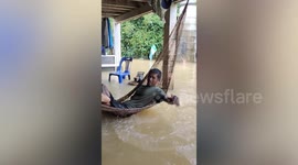 Debris-filled flood swamps family's home following heavy rain in eastern Thailand