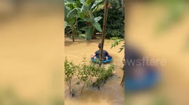 Residents use plastic tubs to float through floods in Thailand
