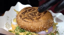 Burger shop heat stamps buns with Thai tribal tattoo designs for good luck