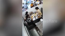 Woman falls from seat while busily taking photos of food at restaurant