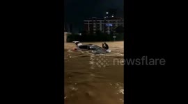 Heroic locals deploy rope to rescue motorists stranded atop flooded car in China