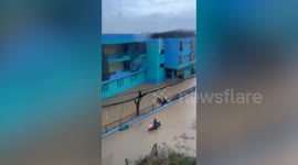Lone motorcycle rider powers through flooded road amid floods in northeast Thailand