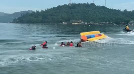 Banana boat beachgoers loses wig in sea when inflatable capsizes