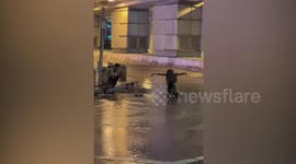 Woman poses for pictures on rainy street during Typhoon Saola in Hong Kong