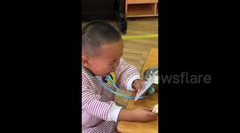Tearful toddler clings to mother's photo at nursery in China