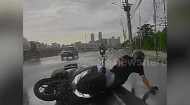 Motorcycle rider distracted while playing on phone slips on wet road