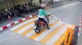 Distracted rider hits gate barrier as he drives while looking at phone