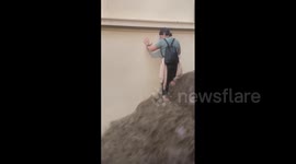 Athens local attempts to descend staircase transformed into waterfall by cascading floodwater