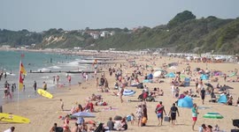 People bask in the sun on Bournemouth beach, UK