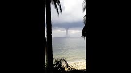 Thick waterspout tornado looms off Philippines coast during thunderstorm