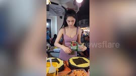 Customers flock to this egg roll stand to watch cook make them in Laos