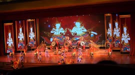 An amazing Thai cultural performance on a dazzling stage, with dancers in traditional costumes, against a background of famous sights in Thailand.