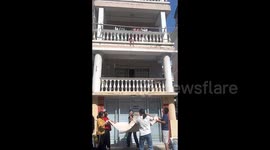 Brave neighbours save toddler teetering on edge of second-floor balcony in China