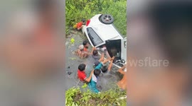 Villagers battle to rescue driver trapped in submerged car