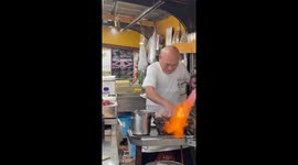 Fast-handed chef uses flamethrower to grill chicken while sprinkling on water to stoke flames