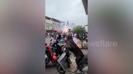 Long-legged Dachshund dog sits on motorcycle while watching firecrackers