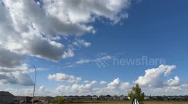 White fluffy clouds speed through the blue skies near Edmonton, Alberta in this time lapse video