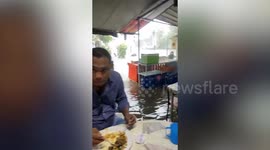 Diners remain unfazed as floodwaters gush inside Thai eatery