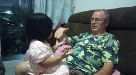 A cute girl is happy to come home to her grandfather.She clapped her hands loudly.