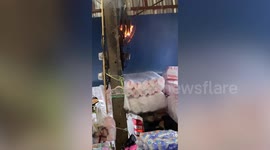 Quick-thinking shopkeeper battles fire from electricity transformer amid heavy rain in Thailand