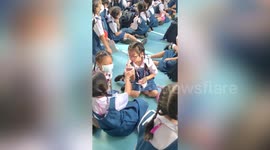 Cute girl does make up with help of classmates at school assembly